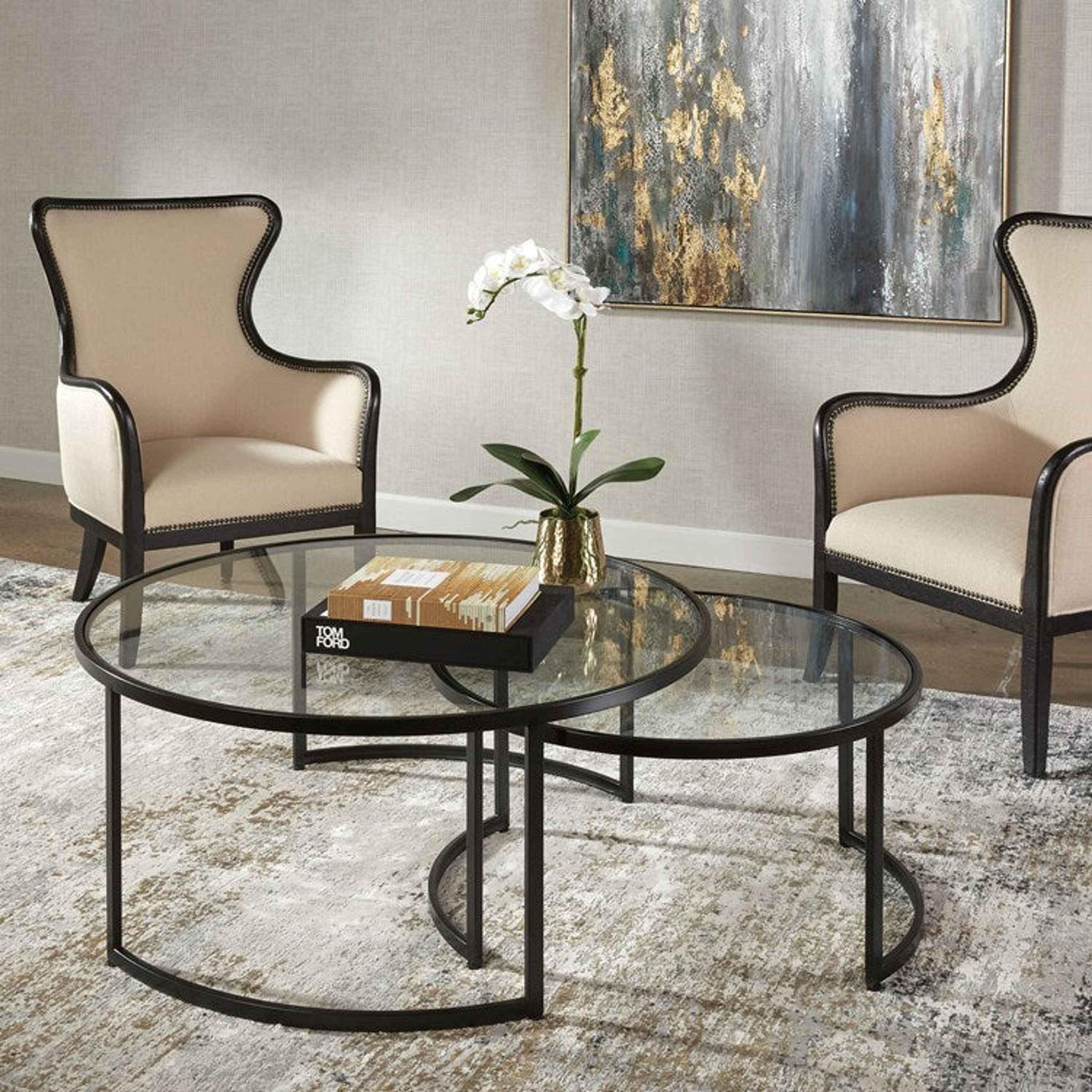 Uttermost Rhea Glass Tops with Black Iron Bases Set of 2 Round Modern Nesting Coffee Tables - Image 1