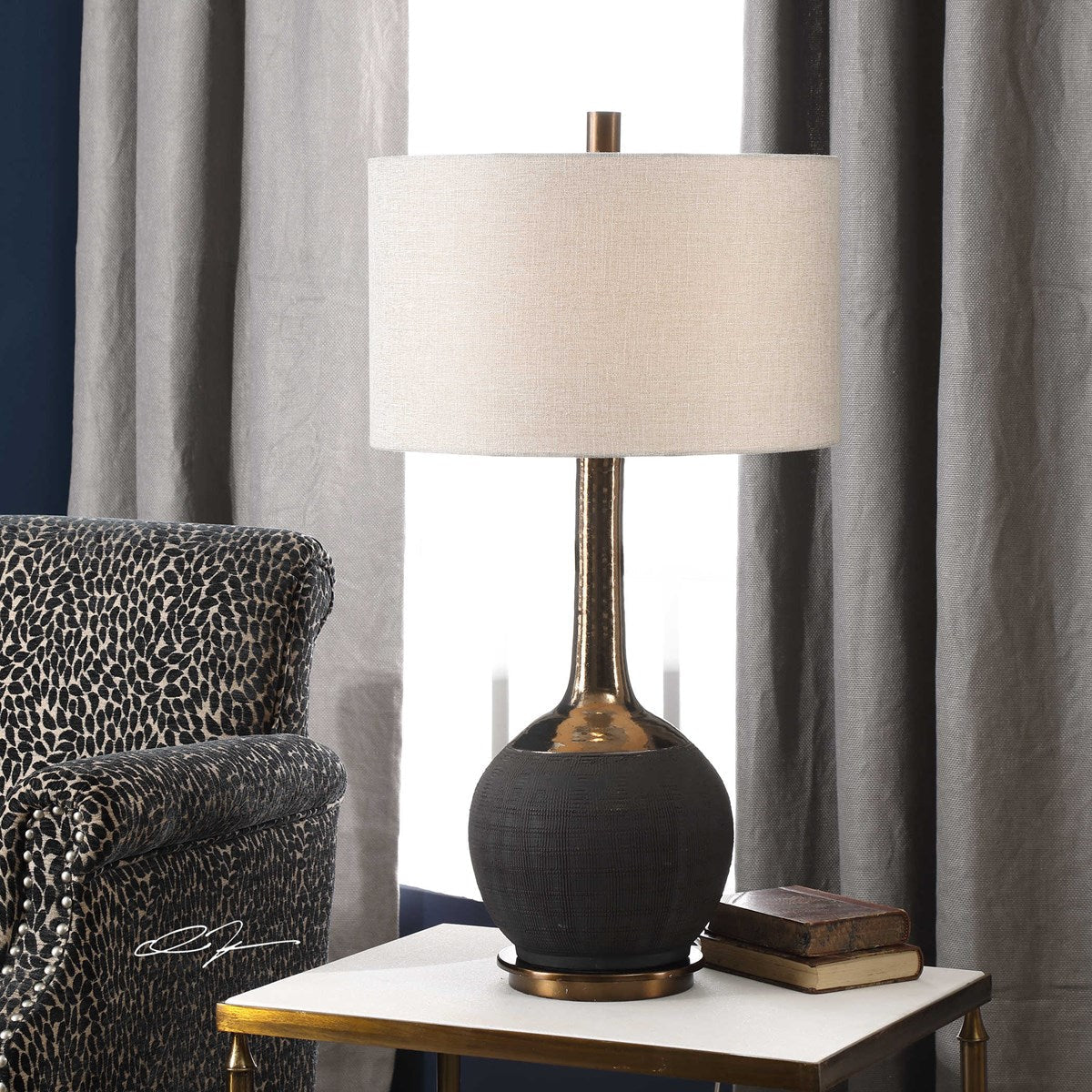 Uttermost Arnav Matte Black and Golden Bronze Table Lamp With Light Gray Linen Drum Shade - Image 1